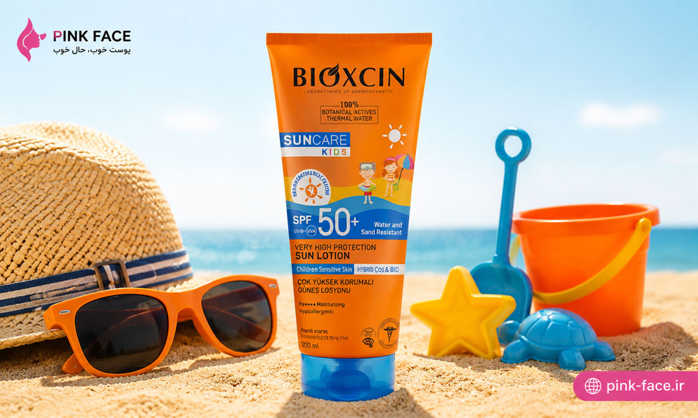 کرم ضدآفتاب کودک بیوکسین ۲۰۰ میل با SPF50 در کنار وسایل ساحلی کودک روی پس‌زمینه روشن